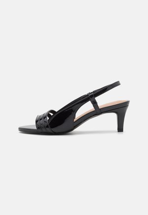Must musträkk nahast slingback kontsaga kingad suletud varbaga, mis on varustatud väikese laotud kontsaga ja risti rihmade detailiga peal.