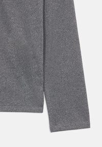 Γκρίζο μπλουζάκι με μακρύ μανίκι από μαλακό, υφή υλικό με ίσια γραμμή και φινίρισμα στο τελείωμα λίγο πάνω από τη μέση. Διαθέτει μανίκι με καρφίτσα.