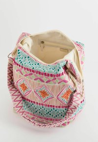 Handbag featuring a textured cotton exterior with colorful geometric patterns in pink, blue, and orange; spacious interior with a zipper pocket.