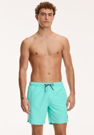 Törökzöld fürdőshorts, rugalmas derékkal és húzózsinórral, bal oldalon egy kis logóval.