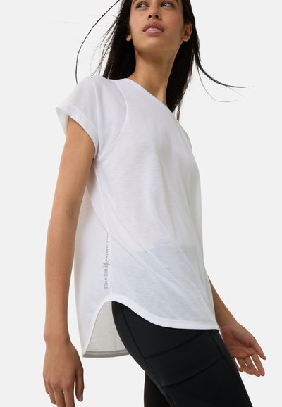 Hvid atletisk T-shirt med korte ærmer, en buet kant og sidelæns detaljer med diskret brandbogstavering i grå.