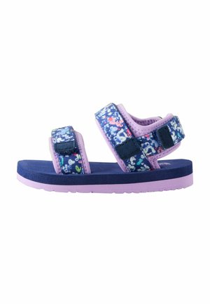 Lilla sandal med blomstret mønster i blå og pink. Velcrolukning, polstret fodseng og tekstureret ydersål for godt greb.