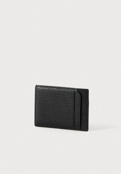 Tarjetero de cuero negro con textura de grano, que cuenta con una ranura superior para tarjetas y una forma rectangular delgada. Diseño simple y minimalista.