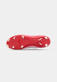 Red cleated outsole with white accents. Smooth, textured surface with distinct traction patterns and six conical studs for grip.