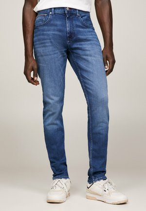 Jeans in denim blu a vestibilità slim, con cinque tasche, leggera scoloritura e dettagli in metallo argentato. Abbinate a sneaker bianche.