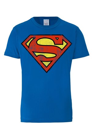 Blue cotton t-shirt featuring a prominently printed red and yellow Superman logo in the center, with a distressed texture.
