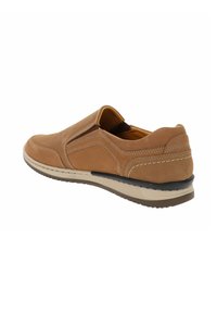 Zapato slip-on de color marrón claro con parte superior de ante texturizado, costuras en contraste y suela de goma. Los paneles laterales presentan un diseño perforado.