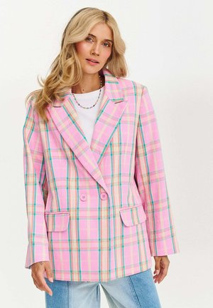 Růžový kostkovaný blejzr má dvouřadý střih, velké klopy a dvě přední kapsy. Akcenty zahrnují světle modré a žluté pruhy.