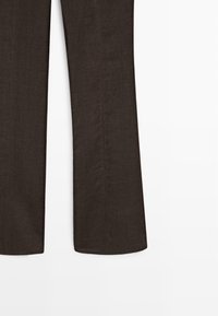 Mørkebrune hørbukser med vide ben vist fra midt på låret til kanten på en hvid baggrund.