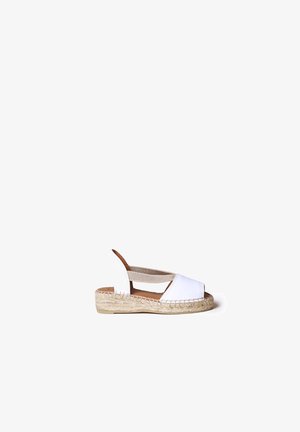 Sandale espadrille blanche à bout ouvert avec brides croisées élastiques et semelle plateforme en jute tressée sur fond blanc.