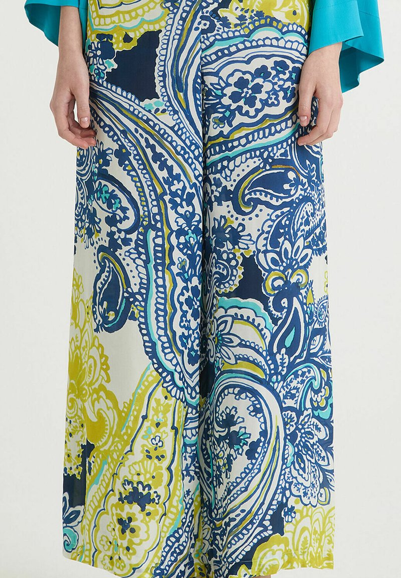 Pantalons larges en tissu léger, ornés d'un motif cachemire coloré dans des tons de bleu, jaune et vert, d'une texture lisse.