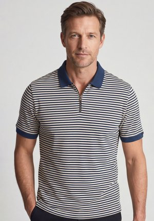Man draagt een navyblauw-wit horizontaal gestreept poloshirt met een navyblauwe kraag en korte mouwen, staand tegen een effen achtergrond.