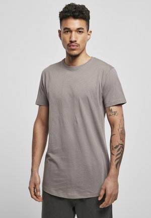 Graues kurzärmeliges T-Shirt in lässiger Passform, aus weichem Stoff. Mit einem runden Halsausschnitt und glatter Textur. Akzentuiert durch sichtbare Tattoos am Arm.