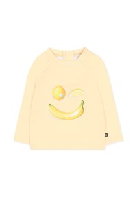 Jasnożółta koszula z długim rękawem z uśmiechającą się twarzą składającą się z cytryny, plasterka cytryny i banana na przodzie.