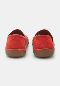 Zapatos slip-on de ante rojo con parte superior texturizada, suela de goma marrón y acentos elásticos en las aberturas, vistos desde la parte de atrás.