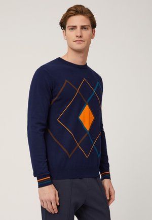 Maglione blu navy con motivo a diamante in arancione, teal e marrone. Polsini a costine con strisce arancioni e teal. Design classico a girocollo.