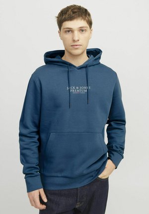 Marineblå hoodie lavet af blødt stof, med en kengurulomme, justerbar snoretrækshætte og logo tekst på forsiden.