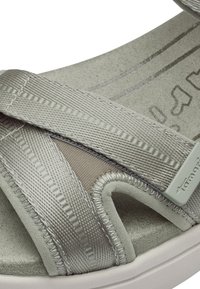 Gray sandal featuring a cross-strap design made of textured fabric, cushioned footbed, and a light-colored rubber sole.