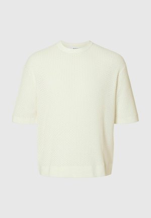 Suéter de punto de manga corta en color crema con un patrón texturizado de panal y un escote redondo. Corte casual con un diseño limpio.