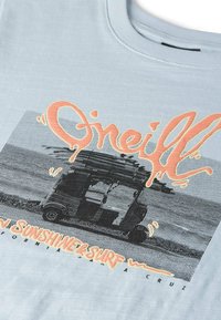 T-shirt en coton bleu clair avec un graphisme noir et blanc d'un van de surf, accompagné d'un texte orange indiquant "O'Neill Sunshine & Surf".