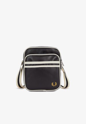Petit sac noir bandoulière avec bordure blanche, poche zippée à l'avant et sangle blanche réglable avec une bande noire.