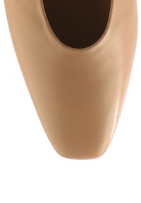 Jasno beżowy skórzany czółenek z okrągłym noskiem i gładką fakturą. Posiada wycięcie na górze. Subtelny połysk na powierzchni.