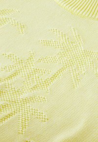Tejido de punto amarillo claro con patrones de palmeras en relieve. Textura suave con un cuello acanalado, que destaca un diseño suave y acogedor.