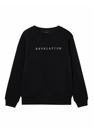 Czarna bluza z długim rękawem i okrągłym dekoltem, z białym napisem „REVELATION” umieszczonym na środku przodu.