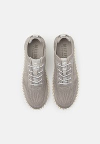 Graue gestrickte Sneakers mit strukturiertem Obermaterial, flachen grauen Schnürsenkeln, Gummisohle und einem Logo-Tag an der Zunge.