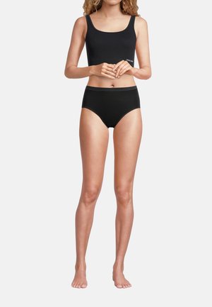 Top corto nero con spalline larghe abbinato a slip neri a vita alta, entrambi realizzati in un tessuto morbido e elastico, con cuciture minime.