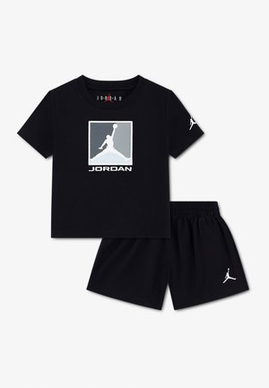 Μαύρο κοντομάνικο μπλουζάκι Jordan με λογότυπο Jumpman και αντίστοιχα μαύρα σορτς με λογότυπα Jumpman στο αριστερό μανίκι και πόδι.