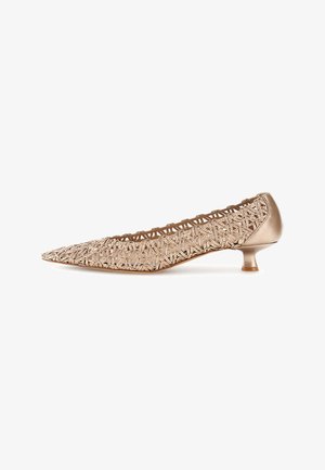 Zapato de salón de punta afilada en bronce con parte superior de tejido entrelazado y tacón bajo estilo kitten sobre fondo blanco.
