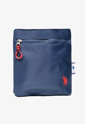 Estuche rectangular azul marino con cremallera en la parte superior, tira roja, pequeño logo bordado en rojo de jugador de polo y etiqueta lateral de tela de la marca.
