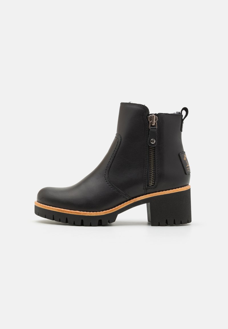 Bottine en cuir noir avec un dessus texturé, fermeture éclair latérale et un talon bloc robuste. La semelle en caoutchouc présente des motifs pour une meilleure adhérence.