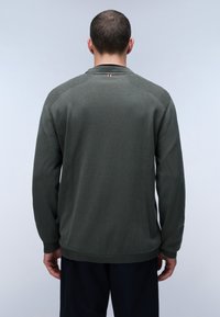 Maglione verde scuro con un lavoro a maglia testurizzato e polsini a coste, caratterizzato da un piccolo accento tri-color al collo. Nessun motivo visibile.