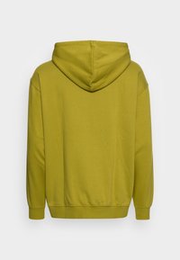 Felpa con cappuccio verde oliva, realizzata in tessuto morbido. Presenta una vestibilità rilassata, polsini e orlo a coste, con un design posteriore senza cuciture.