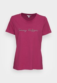 Koszulka z krótkim rękawem, okrągłym dekoltem w fuksjowym kolorze z bawełny, z haftowanym srebrnym napisem "Tommy Hilfiger" z przodu oraz małym akcentem logo na rękawie.
