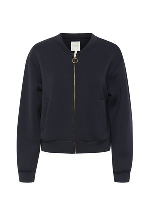 Tamsiai mėlynas džemperis, pagamintas iš minkštos medžiagos, su užtrauktuku priekyje ir auksiniu užtrauktuku, dviem šoninėmis kišenėmis ir briaunotais rankogaliais bei apačia.