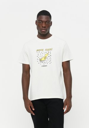 White cotton t-shirt featuring a yellow bird graphic with the text "BREAK FREE!" and black stars, crew neckline, relaxed fit.
