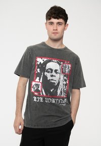 Gray cotton t-shirt featuring a black-and-white graphic of a person framed in red, with text "LIL WAYNE" printed in black at the bottom.