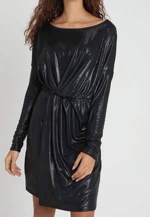 Schwarzes, langärmeliges Kleid aus glänzendem, elastischem Stoff. Mit einem verdrehten Frontdetail und entspannter Silhouette. Glatte Textur, knielang.