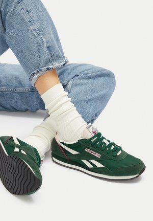 Zapatilla de running verde de ante y malla con acentos en blanco y rojo, suela de goma negra texturada y un diseño clásico.