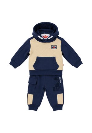 Ensemble de survêtement deux pièces pour tout-petit avec sweat à capuche bleu marine et beige et pantalon, comprenant une poche avant, une impression de texte et une poche de style cargo sur le pantalon.