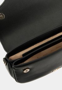 Borsa a tracolla in pelle nera con dettagli dorati, caratterizzata da una superficie liscia, multiple sezioni e un rivestimento interno beige.