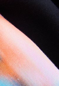 Dva uzorka tkanine: jedan prikazuje gradijent pastelnih boja s glatkom teksturom, dok je drugi čvrste crne boje s rebrastom teksturom.