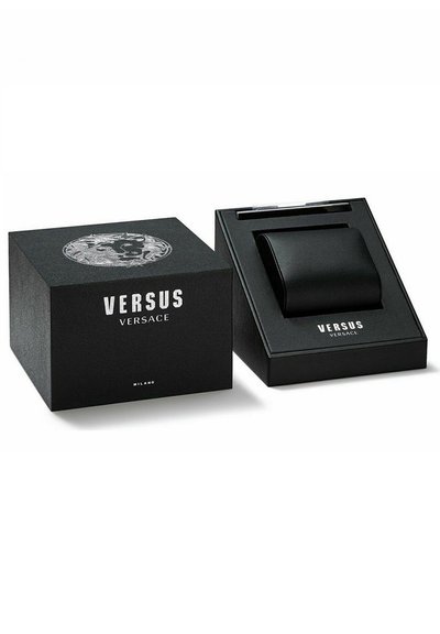 Caja de regalo negra texturizada con un logo plateado de Versus Versace, mostrando un elegante artículo de cuero negro en su interior.
