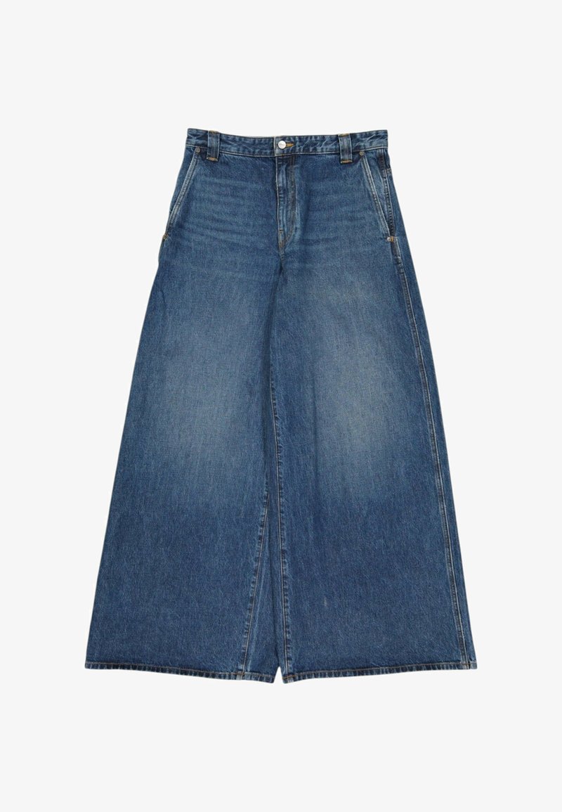 Jean denim bleu à jambes larges avec poches avant, passants de ceinture et fermeture par bouton à la taille, posé à plat sur un fond blanc.