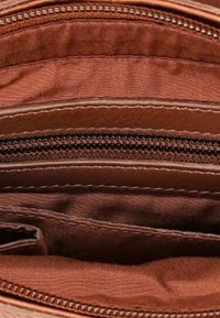 Interno di un portafoglio in pelle marrone con più scomparti e una tasca con zip nera visibile.