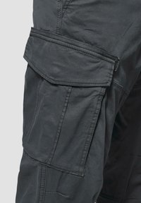 Grijze cargobroek met meerdere zakken, een zachte stoftextuur en versterkte stiksels. Het ontwerp omvat een omslagflap op het been.