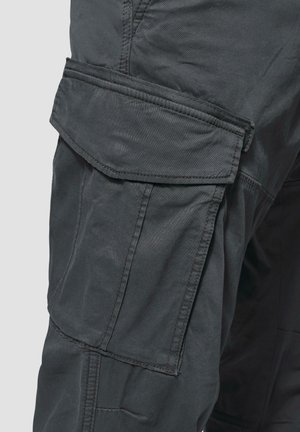 Hallitus hallid lasta püksid, mis sisaldavad mitmeid taskuid, pehmet kangast tekstuuri ja tugevdusõmblusi. Disain sisaldab jala küljes volditavat klappi.